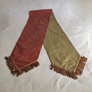 Red and gold tapestry table runner with fringe and tassels